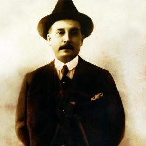 Imagen Fotografia Jose Gregorio Hernandez Posando Cuerpo Entero Parado Brazos Cruzados Detras Espalda Estudio Fotografico Ramirez y Compañia Fondo Neutro Texturizado Traje Negro Pañuelo Adornando Solapa Camisa Blanca Corbata Negra Sombrero Negro